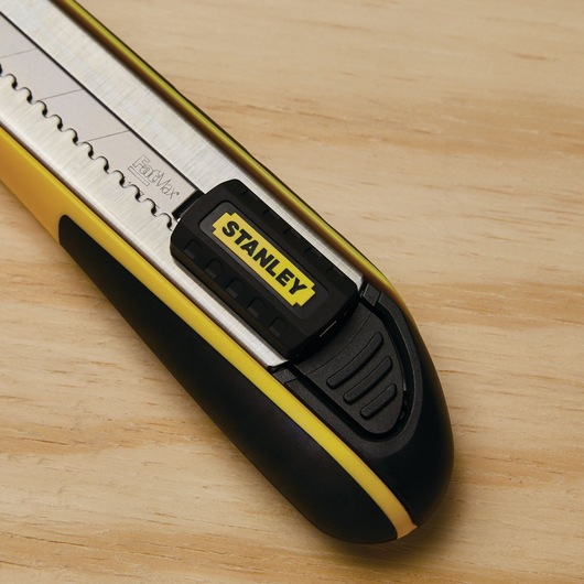 Stanley 10-486 retractable utility knife close-up, yellow and black handle, on wood surface.