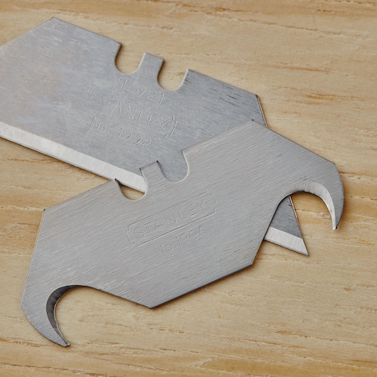 STANLEY 10-499 utility blades with curved hooks on wood surface, close-up photography.