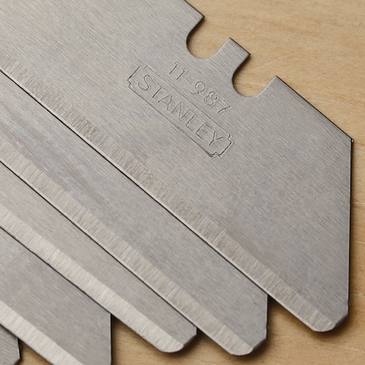 Photo of STANLEY 11-987 utility blades, close-up view showing metal surface and sharp edges.