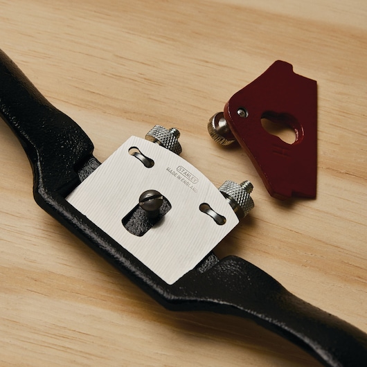 STANLEY 12-951 spokeshave tool with black handle and metal blade, shown disassembled on a wooden surface.