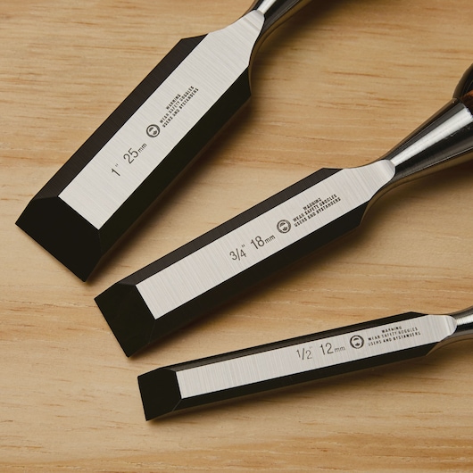 STANLEY 16-970 set of three wood chisels with beveled edges, shown on wood surface, close-up view.