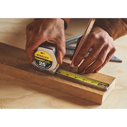 Stanley 33-425 PowerLock tape measure in use on wood, product photography.