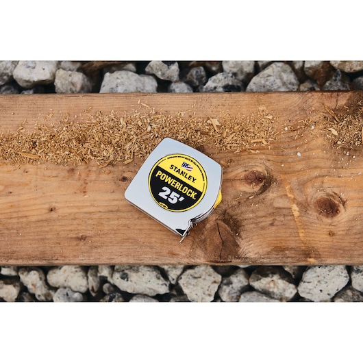 STANLEY 33-425 tape measure on wood plank with sawdust, exterior view.