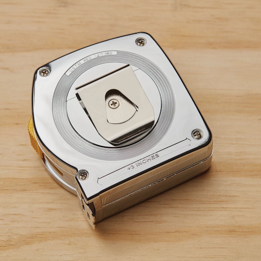 STANLEY 33-425 chrome tape measure with belt clip, square case, top view on wooden surface