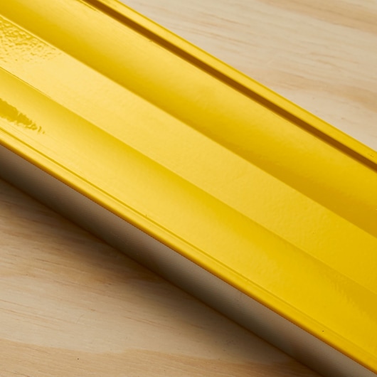 Photo of STANLEY 43-524 yellow level tool, close-up side view on wood surface.
