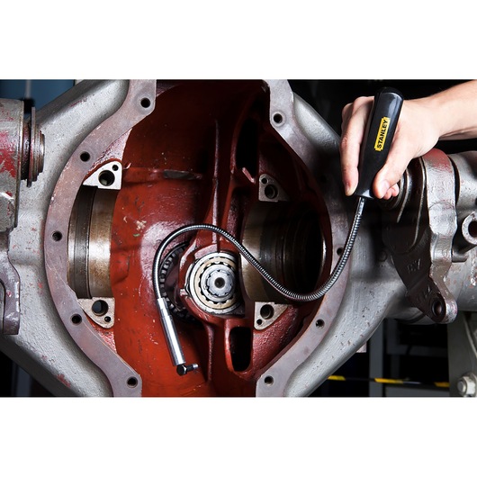 Photo of STANLEY 78-020 flexible magnetic pickup tool being used to retrieve small parts from machinery.