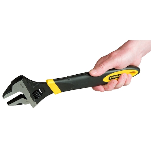 Photo of STANLEY 90-950 adjustable wrench with black and yellow handle, held in hand, side angle.