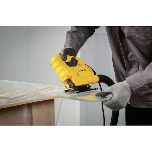 Stanley SJ45 jigsaw power tool in use cutting clear plastic sheet, close-up photography.