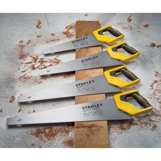 STANLEY STHT20375-LA heavy duty hand saws with yellow handles on wood, angled view, surrounded by sawdust.