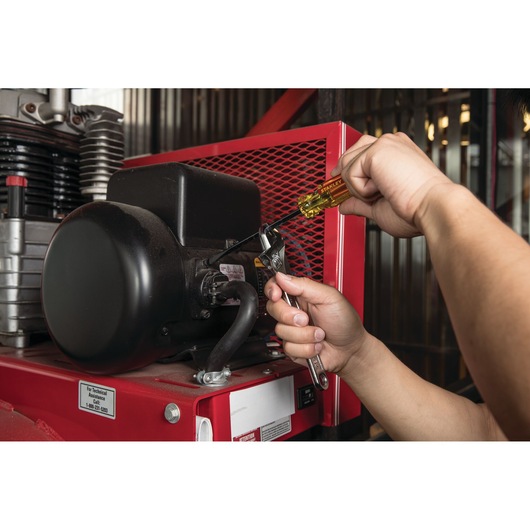 Photo of a person using the STANLEY STHT69176 screwdriver and wrench to repair machinery.