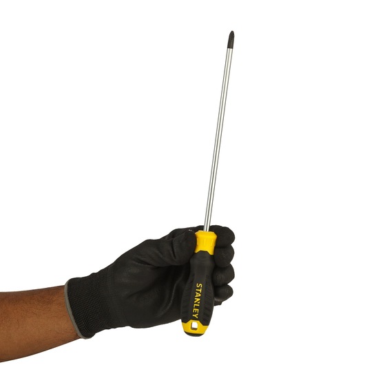 Photo of STANLEY STMT60812-8 Phillips screwdriver with black and yellow handle, held in gloved hand, side angle.