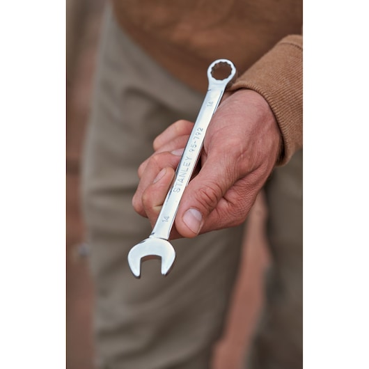 STANLEY STMT82832-LA combination wrench held in hand, silver finish, outdoor background.