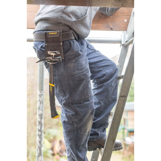 STANLEY STST1-80117 tool belt pouch holding hammer, shown on person climbing ladder, product photography.